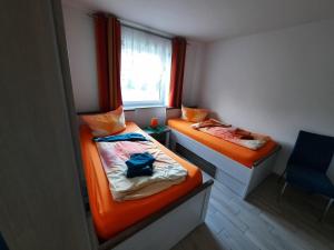 two beds in a small room with a window at Haus-Hempel-1 in Groß Mohrdorf