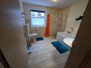 a bathroom with a tub and a shower and a sink at Haus-Hempel-1 in Groß Mohrdorf