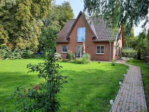 a brick house in a yard with a green lawn at Haus-Hempel-1 in Groß Mohrdorf