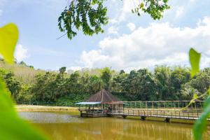 a bridge over a lake with a gazebo at mist valley in Ban Nong Chaeng