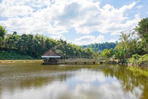 a bridge over a lake with a gazebo at mist valley in Ban Nong Chaeng