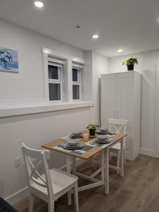 a dining room with a table and chairs at Modern 2BR Suite Steps to SkyTrain in Vancouver