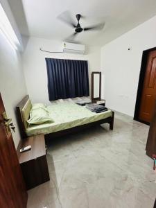 a bedroom with a bed with a ceiling fan at Mangalore serviced flats in Mangalore