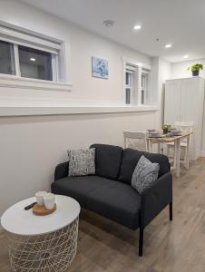 a living room with a couch and a table at Modern 2BR Suite Steps to SkyTrain in Vancouver
