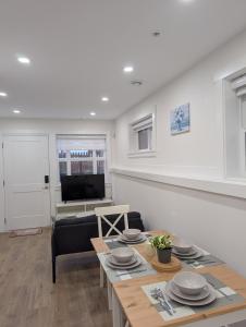 a living room with a table and a couch at Modern 2BR Suite Steps to SkyTrain in Vancouver