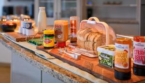 a counter top with bread and condiments on it at Welcome Bay Heights in Tauranga