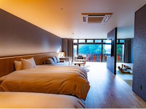 a hotel room with two beds and a balcony at Hotel Flags Sasebo KujuKusima in Sasebo