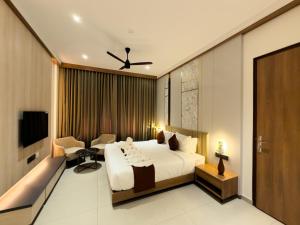 a bedroom with a bed and a couch and a tv at Dwaraka INN in Arīkkod