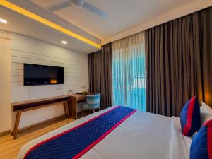 a hotel room with a bed and a desk and a television at Zip By Spree Hotels Ranjangaon in Ranjangaon Ganpati