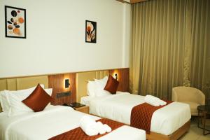 a hotel room with two beds with white sheets at Dwaraka INN in Arīkkod +124 photos