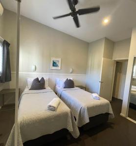 a bedroom with two beds and a ceiling fan at Margarets Forest in Margaret River Town