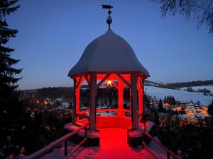 a gazebo with red lights on it at night at Ferienwohnung Heidi in Annaberg-Buchholz