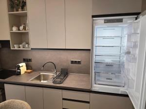 a kitchen with an empty refrigerator next to a sink at Velithea Luxury Suites in Ioannina +153 photos
