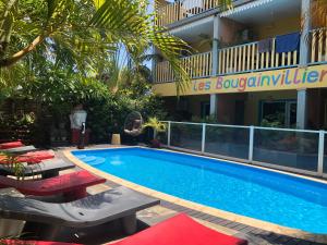 a swimming pool in front of a hotel at Hôtel les Bougainvilliers in Saint-Gilles-les-Bains