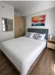 a bedroom with a large white bed and a window at Sebby Studio in Bacolod +9 photos