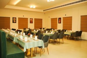 a dining room with tables and chairs and tablesktop at Dwaraka INN in Arīkkod
