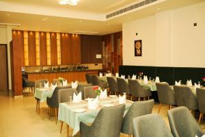 a dining room with tables and chairs and a chef at Dwaraka INN in Arīkkod