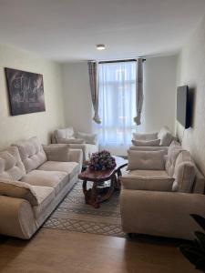 ein Wohnzimmer mit zwei Sofas und einem Tisch in der Unterkunft Maisha Mapya in Gatimu