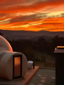 a room with a view of a sunset at Romantic Stargazing Retreat - Beyond Bubbles in Kanimbla