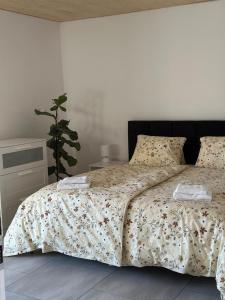 a bedroom with a bed with a floral bedspread at Brezový dvor in Svätý Anton