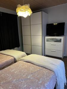 a bedroom with two beds and a flat screen tv at Aurora Gateway N4 in Inari