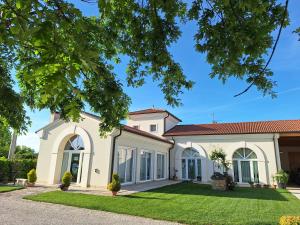 a large white house with large windows and a yard at B&B Borgo Arcadia in Poiana Maggiore