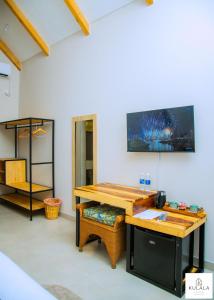 a room with a desk with a television on the wall at Kulala Stays Lodge in Livingstone