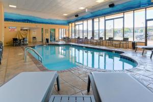 a large swimming pool in a building with windows at Comfort Inn & Suites at Dollywood Lane in Pigeon Forge