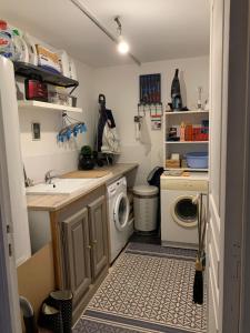 a small kitchen with a sink and a washing machine at Maison cocooning in Hazebrouck