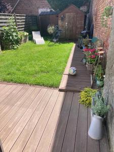 a backyard with a wooden deck with a lawn at Maison cocooning in Hazebrouck