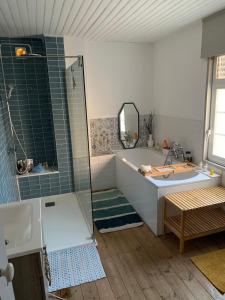 a bathroom with a tub and a shower and a sink at Maison cocooning in Hazebrouck +8 photos
