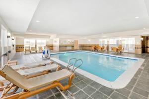 a large swimming pool with chairs and a table at Comfort Suites Pecos in Pecos