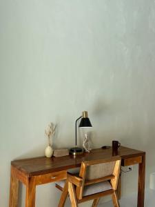 ein Holzschreibtisch mit einem Stuhl und einer Lampe darauf in der Unterkunft Suenos Villas Siargao in General Luna