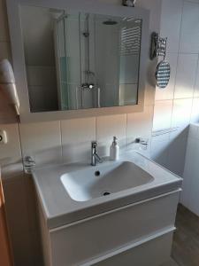 a bathroom with a white sink and a mirror at Gästehaus Sol Tour in Ahrensfelde +34 photos
