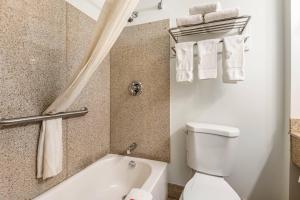 a bathroom with a tub and a toilet and towels at Econo Lodge Saint Albans in Saint Albans +12 photos