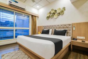 a bedroom with a large bed and a window at Townhouse Oak PTC Indore Junction in Indore +52 photos
