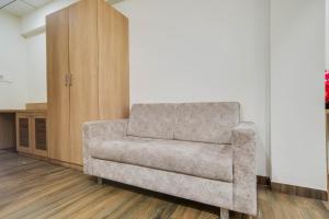 a gray couch in a room with a cabinet at Townhouse Oak PTC Indore Junction in Indore