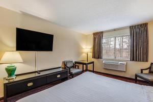 a hotel room with a bed and a flat screen tv at Econo Lodge Whitehall near Michigan's Adventure in Whitehall