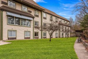 a building with a green lawn in front of it at Econo Lodge Whitehall near Michigan's Adventure in Whitehall