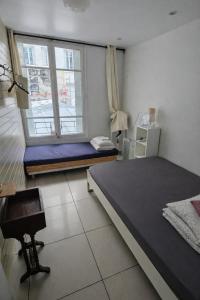 a room with two beds and a window with a chair at Korean Style Minbak Number Two PARIS in Paris