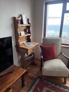 a living room with a desk and a chair and a television at Vistas al Mar in Great Brak River