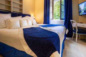 a bedroom with a blue and white bed with a desk at Le Clos Violette et Le 11 D'Aglaé - Appart' Hôtel de Charme Design de Luxe in L'Isle-sur-la-Sorgue +155 photos