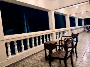 a chair and a table in a room with windows at The Kasbo in Unawatuna