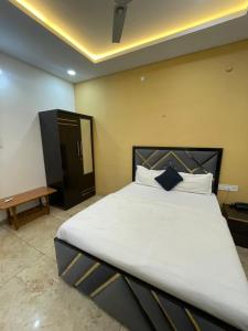a bedroom with a large bed with white sheets and pillows at Hotel shree shiv in Indore