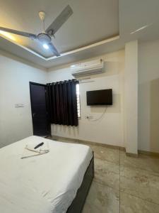 a bedroom with a bed and a tv on the wall at Hotel shree shiv in Indore +13 photos