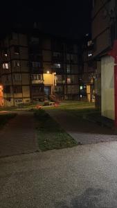 an empty street in front of a building at night at Topola centar in Topola
