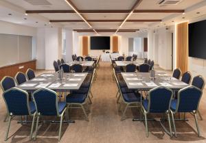 a conference room with tables and chairs and a projection screen at Pefkos City Hotel in Limassol +28 photos