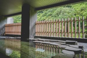 a building with a fence and a pool of water at Hakone Pax Yoshino in Hakone