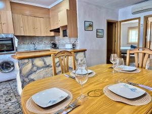 a wooden table with glasses and plates on it in a kitchen at Casa Caloret - Playa y centro a 2 min in Vinarós
