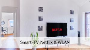 a living room with a tv on a wall at Traumferienwohnung Domblick - Parkplatz inklusive, zentral mit Altstadtblick & Netflix in Limburg an der Lahn